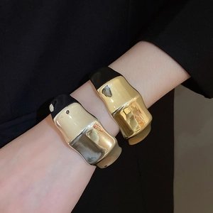 Close-up of gold and silver textured acrylic bangles with irregular ridge design