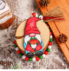 Close-up of a festive wooden gnome ornament with snowflakes on a natural wood log base