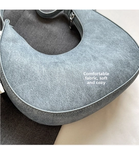 Detail showing the soft textured fabric and fine edge stitching of the grey crescent bag