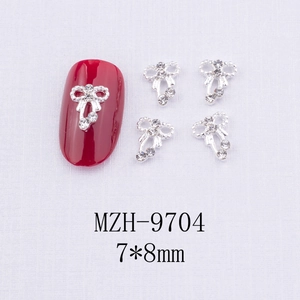 Vue macro de bijoux d'ongles en forme de nœud argenté avec strass, taille 7x8mm