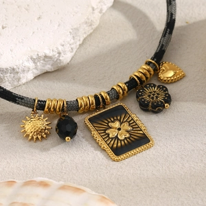 Detail of woven rope necklace featuring 18K gold plated charms and black beads