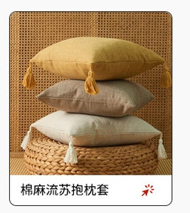 Detail of cotton linen pillow covers with corner tassels in yellow, beige and brown