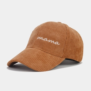 Close-up of white mama embroidery on caramel corduroy baseball cap with textured finish