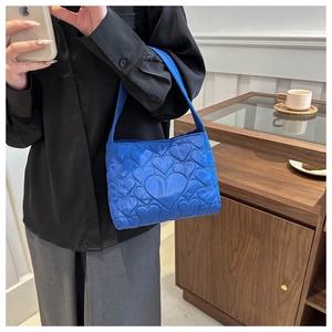 Détail du cabas matelassé bleu roi avec des textures de coutures créatives en forme de cœur