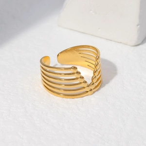 Detail of gold multi-layered geometric ring on white architectural stone backdrop