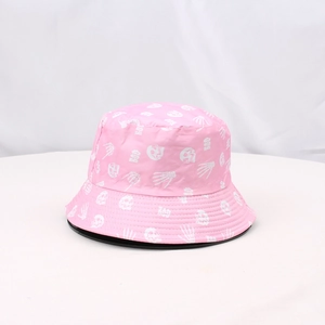 Detail shot of a pink sun hat featuring white skull prints and decorative BOO lettering