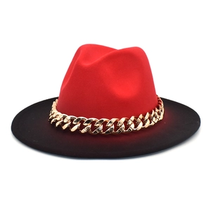 Detail view of the red wool fedora hat with flat black brim and golden chain accessory