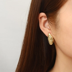 Irregular textured leaf-shaped 18K gold-plated stainless steel earrings on model