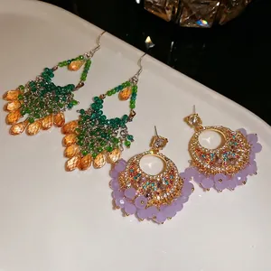French palace style earrings with crystal tassels and gold rings on white porcelain