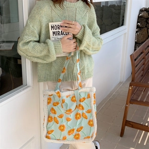 Detail der mintgrünen Canvas-Tasche mit floralem Print und weißem Plüschrand