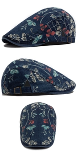 Close-up of floral denim flat cap featuring adjustable bronze buckle and vintage print