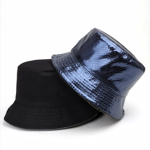 Détails du chapeau bob en coton noir mat et texture d'écailles bleu métallisé brillant