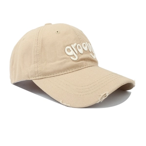 Detail of light beige baseball cap with groovy embroidery and distressed brim edge