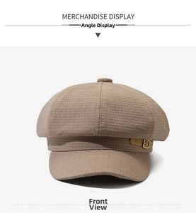 Dettaglio del cappello newsboy cammello con trama a nido d'ape e fibbia in pelle