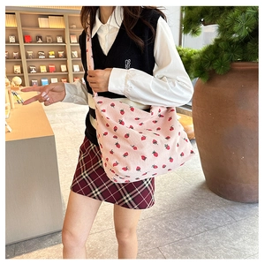 Detail of pink corduroy shoulder bag with sweet strawberry prints and soft texture