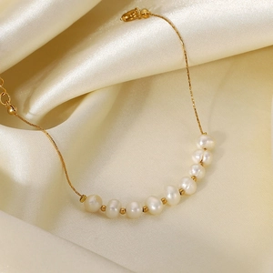 Détail de perles d'eau douce naturelles sur une chaîne en acier plaqué or 18 carats