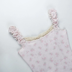 Détail du caraco floral montrant des bretelles à volants et de la dentelle beige