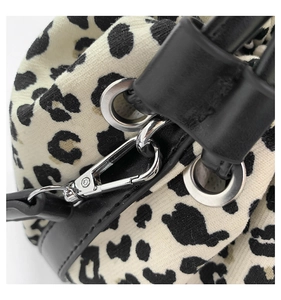 Detail of leopard print fabric with black leather trim and silver metal buckle hardware
