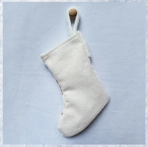 Dettaglio della calza di Natale in morbido peluche bianco con paillettes e pratico gancio