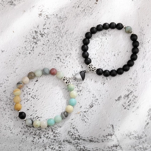 Close-up of heart-shaped magnetic clasp on natural tiger eye and matte bead bracelets
