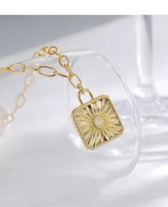 Macro shot of gold-plated sunburst square pendant featuring a round opal stone inlay