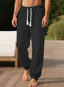 Détail du jogging noir texturé pour homme avec cordons blancs et chevilles resserrées