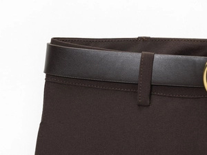 Detail de la couture de la taille et ceinture en cuir synthetique marron sur le short