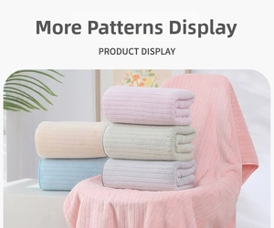 Macro detail of thickened coral fleece towels showing embossed vertical stripe texture