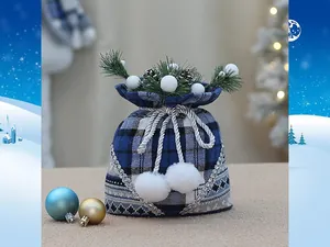 Detailed view of blue plaid Christmas gift bag with pine cones and white plush balls