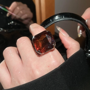 Detailed close-up of a large amber square faceted gemstone ring with claw setting