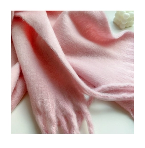 Close-up of soft pink mohair scarf with fringe texture and high-quality knitted finish
