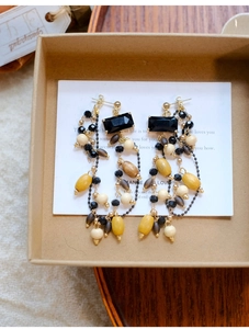 Macro shot of bohemian tassel earrings with black square stone and multi-colored wooden beads