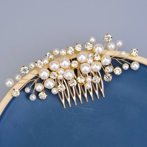 Elegant gold bridal hair comb with white faux pearls and crystals on a blue tray