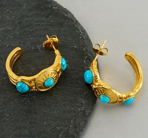Détail de boucles d'oreilles créoles vintage avec turquoise et motif soleil doré