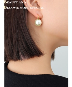Gros plan de boucles d'oreilles élégantes plaquées or 18 carats avec perle crème