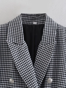 Detailansicht der geprägten Metallknöpfe auf dem klassischen schwarz-weißen Blazer
