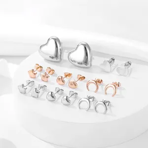Close-up of 9 pairs of heart, star and moon stud earrings in silver and rose gold