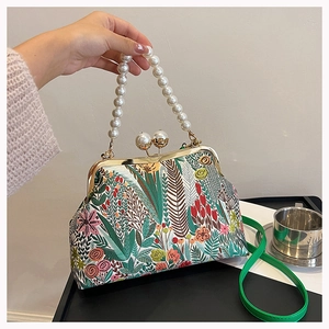 Detail der Blumenstickerei auf Vintage-Handtasche mit Perlenverschluss und Griff