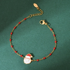 Detail of Christmas bracelet with Santa enamel charm and red beads on a golden chain