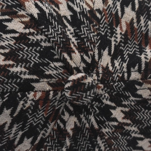 Gros plan sur la texture en tricot pied-de-poule vintage et le bouton de la casquette