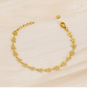 Detailed view of golden stainless steel flower bracelet with turquoise stone inlays