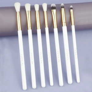 Detailed view of 7-piece eye makeup brush set with white handles and golden ferrules
