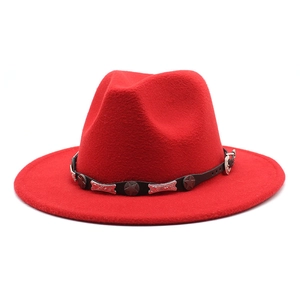 Detail of red wool fedora hat featuring black leather band and silver star metal studs