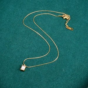 Elegant 18K gold-plated titanium necklace with sparkling rectangular zircon pendant on green fabric