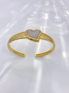 Detailed view of a gold-plated heart-shaped bangle featuring shimmering pavé set cubic zirconia