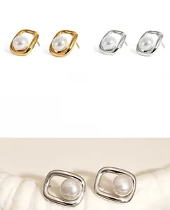 Detail of square PVD plated stainless steel earrings with central white pearl inlay