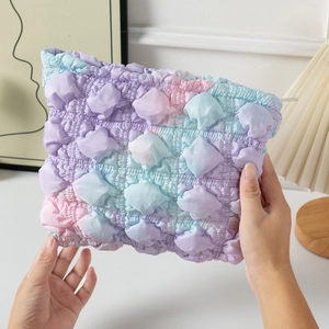 Macro detail of gradient bubble pleated makeup bag showing soft textured fabric and zipper