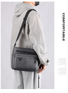 Detail view of grey crossbody bag with multiple zip pockets and adjustable strap