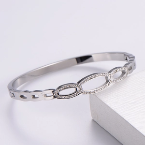 Detail of silver bangle featuring interlocking oval rings paved with sparkling crystals