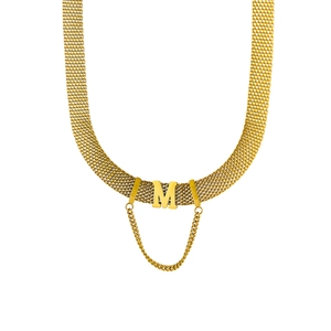 Macro detail of golden mesh necklace featuring a central letter M and MOM engraving detail